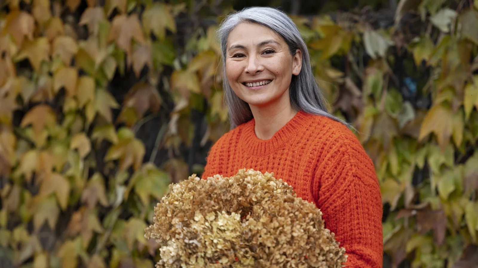 Mature Asian lady with grey hair at autumn